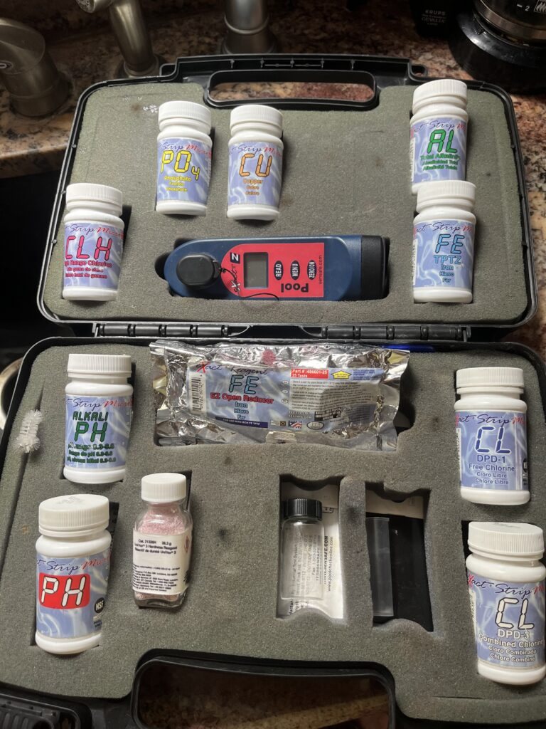 An open professional water test kit with reagent bottles and a digital photometer