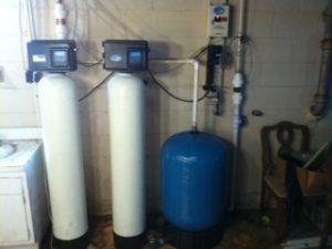 A whole-house treatment train with two tanks and a blue pressure tank